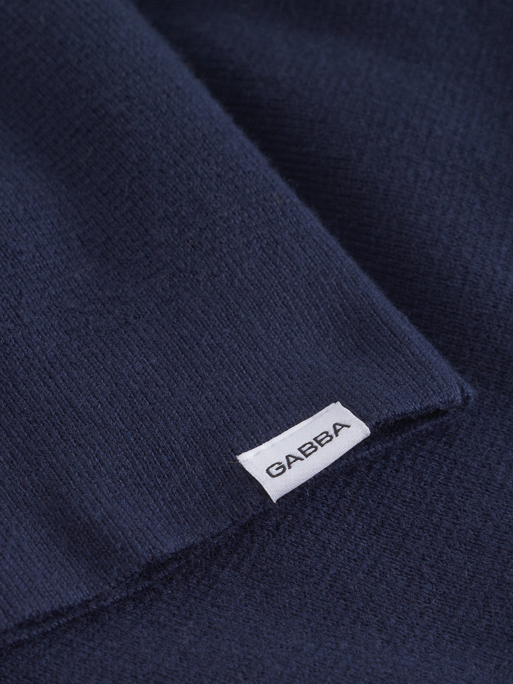 Close-up of the navy cotton-wool blend fabric from Gabba's Blanko New Zip LS, featuring a small stitched white tag with the brand name in black capital letters.