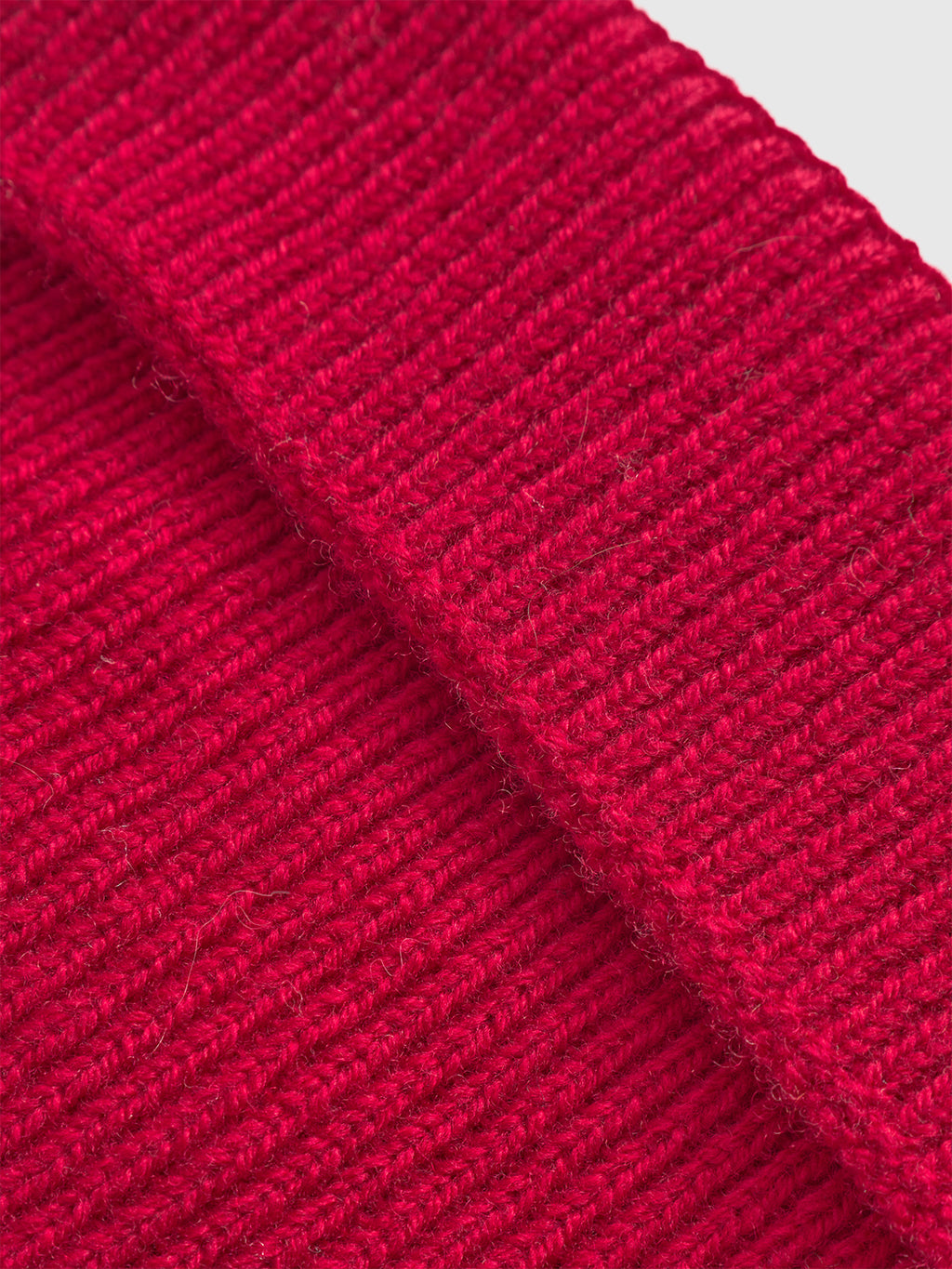 Close-up of the Gabba Biella Aico - Red beanie, highlighting its textured ribbed knit merino wool fabric and folded edge for a cozy, stylish look.