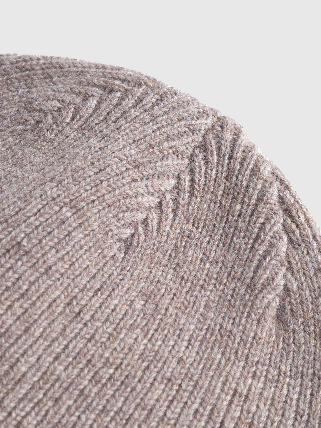 Close-up of the Gabba Biella Aico beanie in light brown, showcasing its detailed ribbed knit texture and stitching—an essential winter accessory set against a plain, light background.