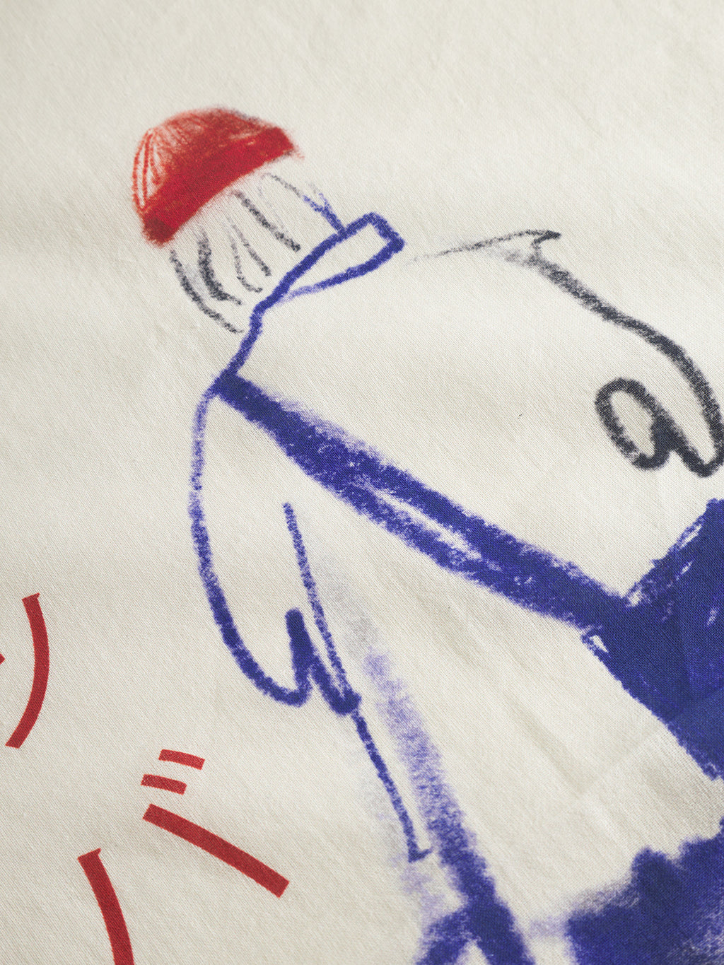 A sketch-style drawing on white fabric shows a person from behind in a red hat and blue clothes, with partial red Japanese text on the left. Product: Bandana Kay - Multi Pattern by Gabba.