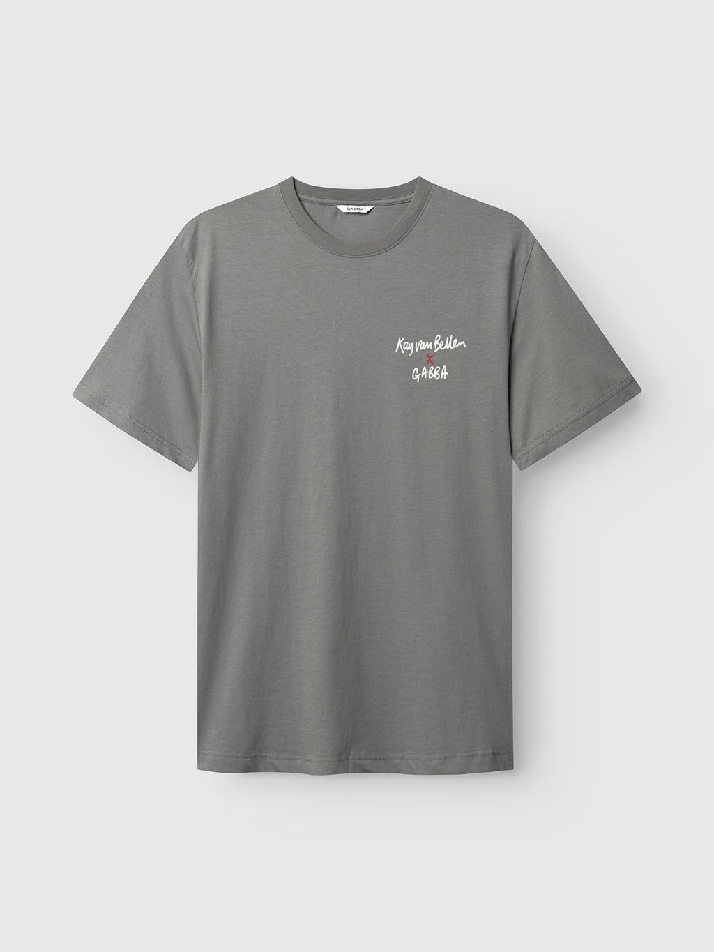 A plain dust sage green short-sleeved organic tee by Gabba, made from GOTS-certified cotton, features white Kenya Edition GABBA text on the left chest and is displayed on a light gray background.