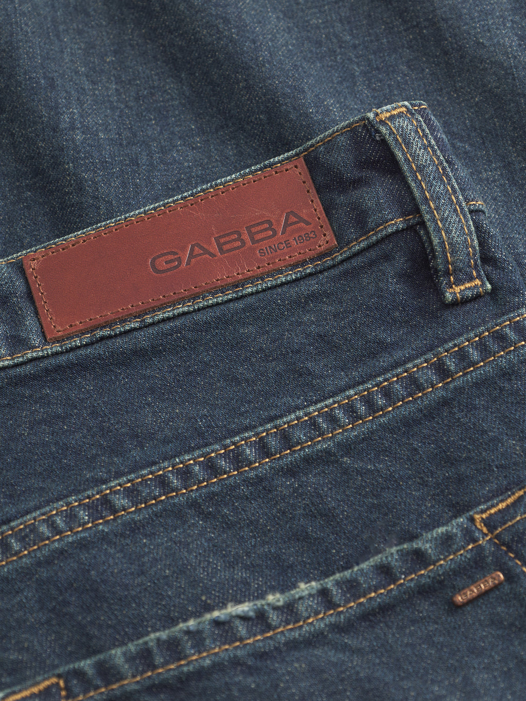 Close-up of Gabbas Marc Dox - Dark Blue Denim jeans: straight leg style with a brown leather waistband patch embossed Since 1983, prominent stitching, and part of the back pocket—timeless vintage workwear detail.