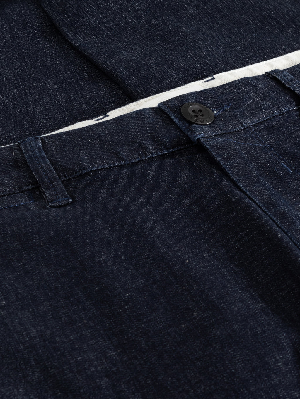 Close-up of Paul Sisu - Dark Denim slim fit jeans by Gabba, showing the waistband, belt loop, black button, and visible white inner lining at the top.