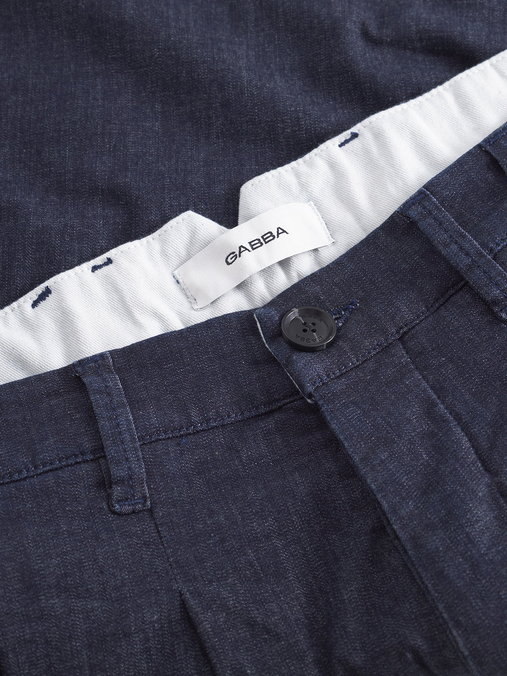 Close-up of Gabba Firenze Sisu relaxed tapered jeans in dark denim, featuring a button fastening, white waistband lining, and a GABBA label.