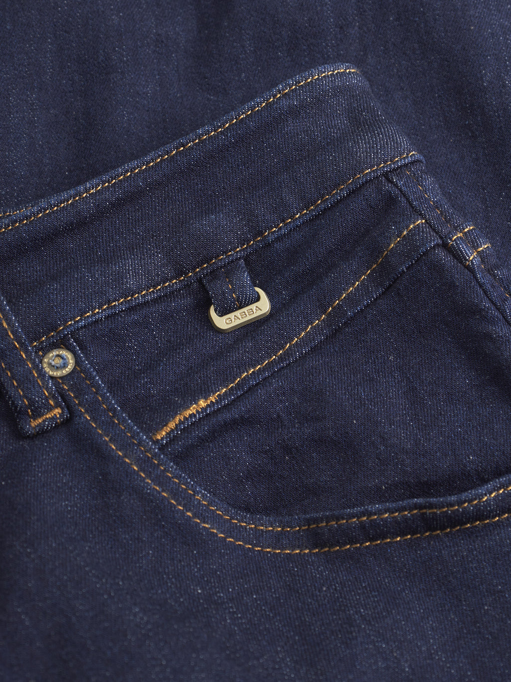 Close-up of the Alex Just - Denim Blue jeans by Gabba, featuring orange stitching, a small metal Gabba tag, and crafted from recycled fibers.
