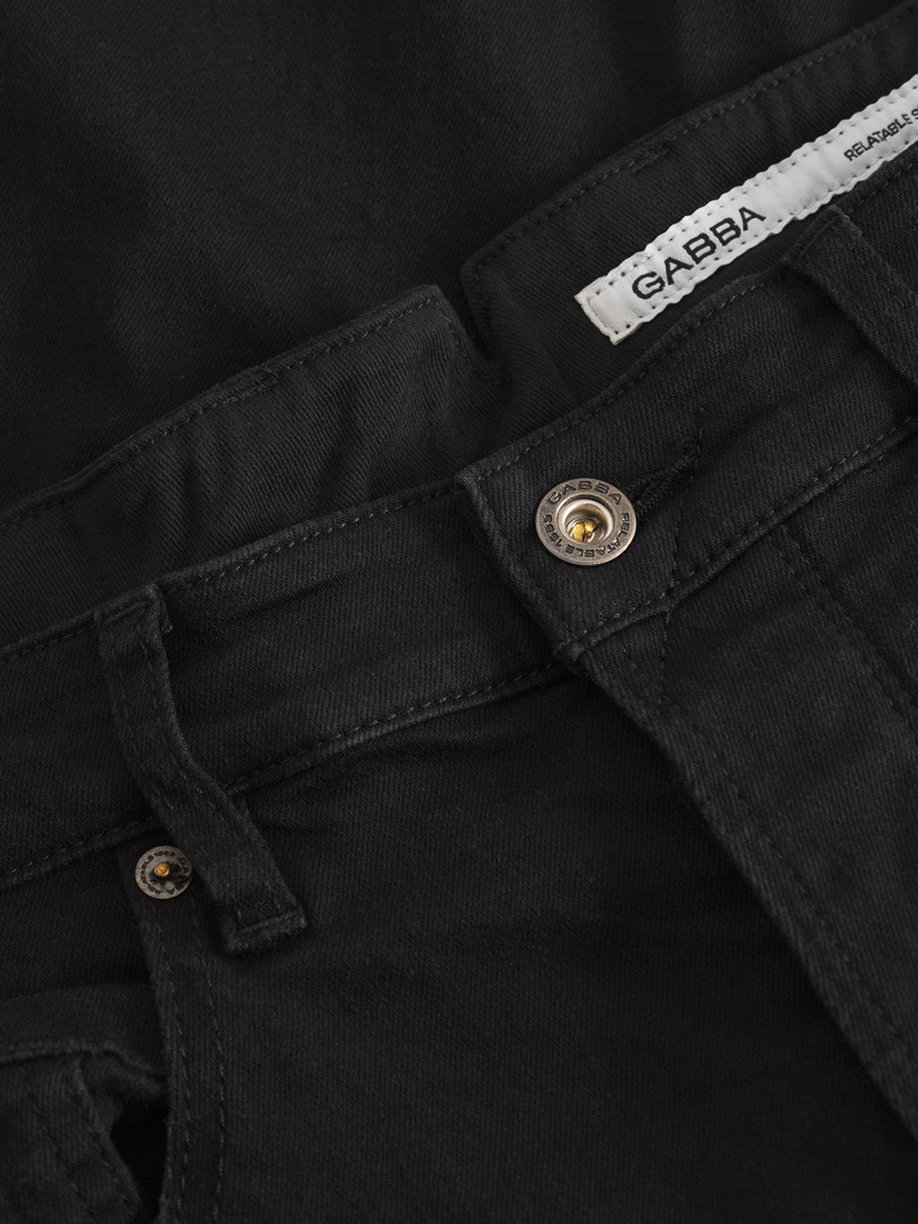 Close-up of Alex Dusa - Black Denim jeans with tapered fit, highlighting the waistband, metal button, belt loop, and a white Gabba label inside.