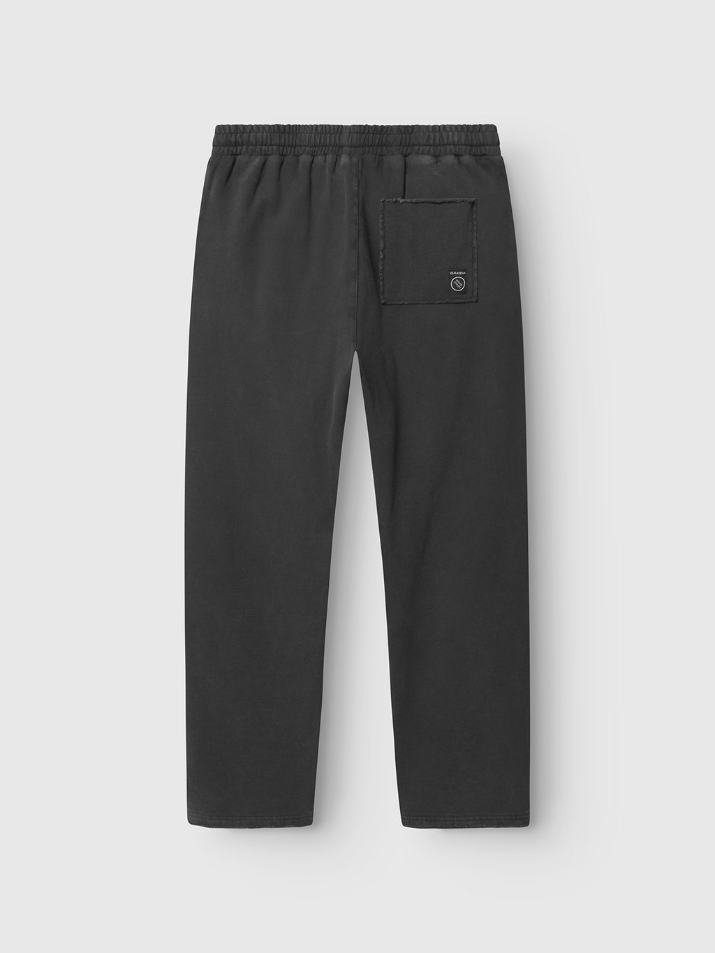 The Gabba Pireo Bump GWC - Black are loose straight-fit cotton jersey pants with an elastic waistband and single square back pocket featuring a small stitched logo, shown laid flat on a light gray background.