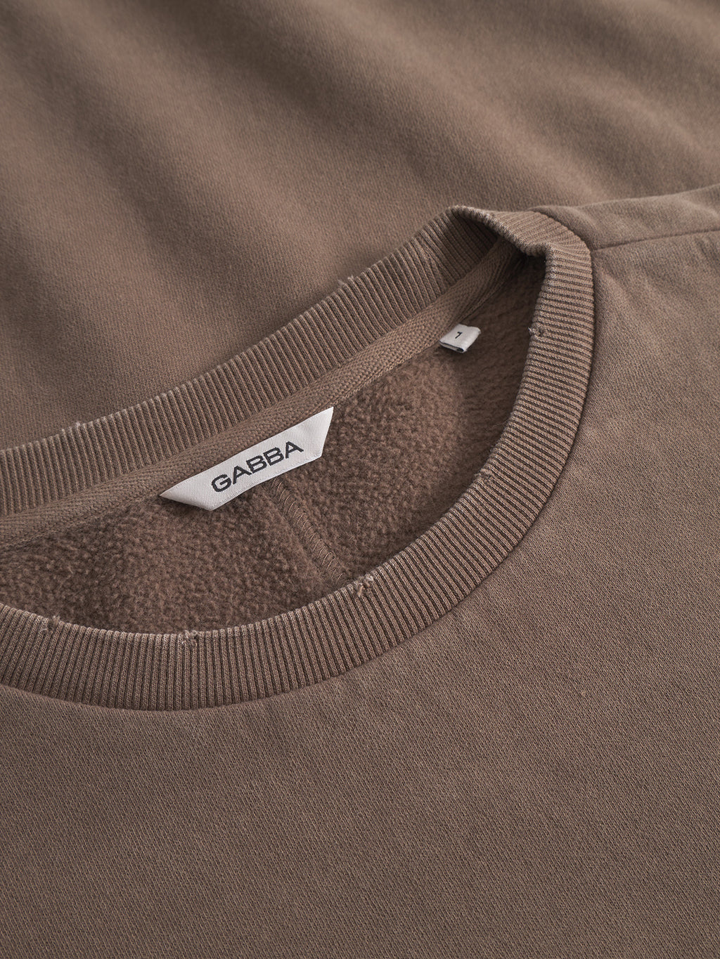 Close-up of the Volos Bump GWC - Brown by Gabba, showing its super-soft crew neck, plush inner lining, and a white Gabba label sewn into the neckline.