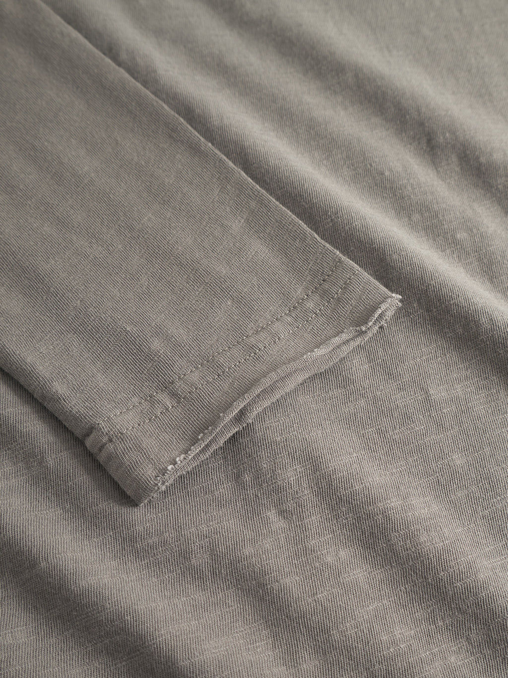 Close-up of the Gabba Paros Rif GWC - Grey long sleeve t-shirt, laid flat to highlight the cuff and textured super soft cotton fabric for a comfortable, easygoing faded look.