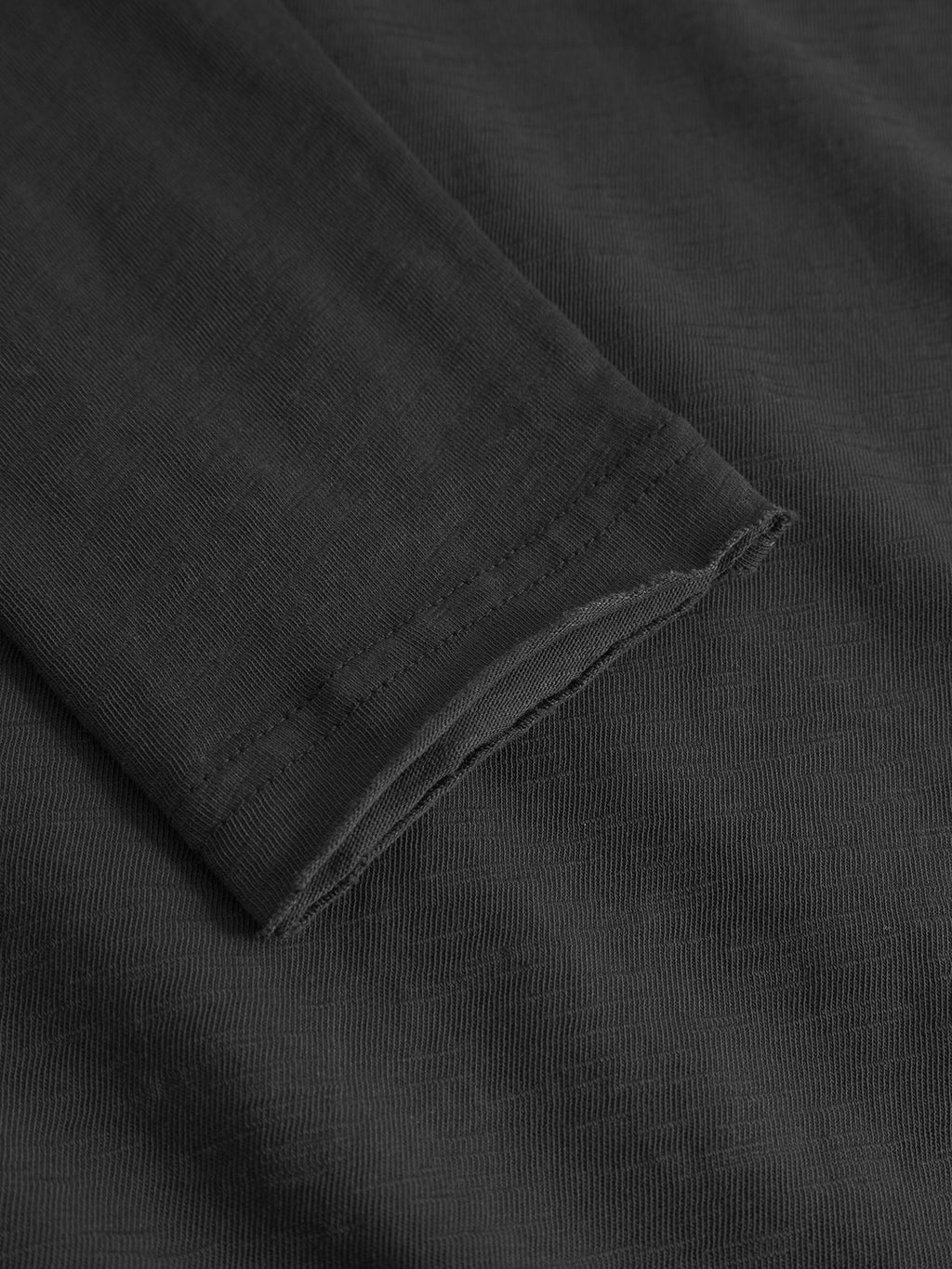 Close-up of the Gabba Paros Rif GWC - Black long sleeve t-shirt, featuring its cotton fabric texture, neat stitching on the cuff and seam, and a subtle faded look.