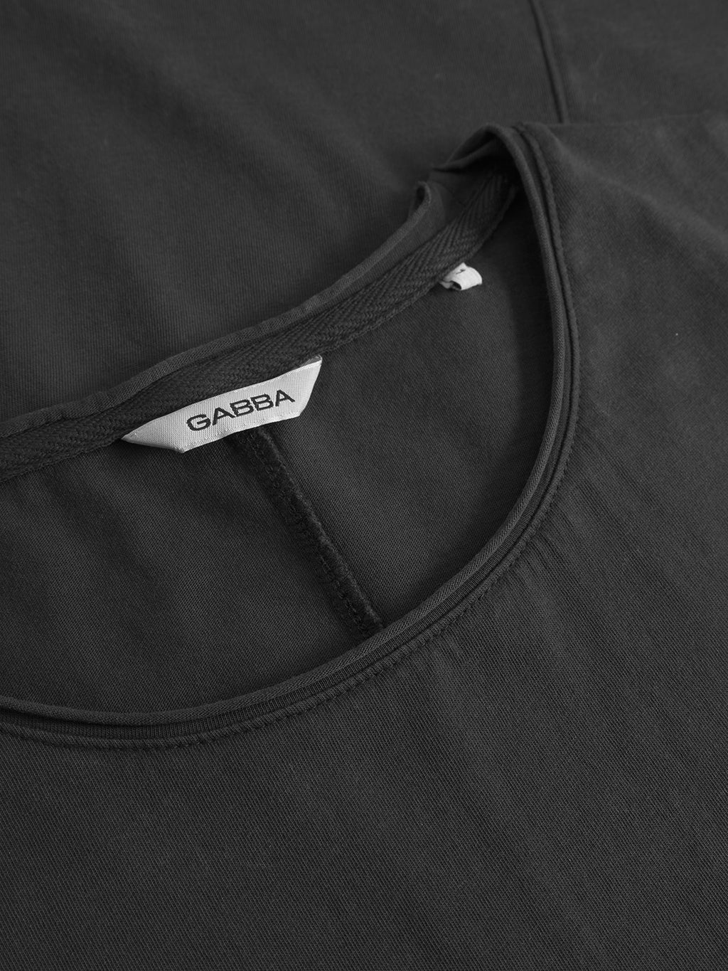 Close-up of the Gabba Idra Rig GWC - Black regular fit t-shirt, showing the neckline with a white Gabba label inside the collar. The image highlights the super soft cotton texture and stitching details.