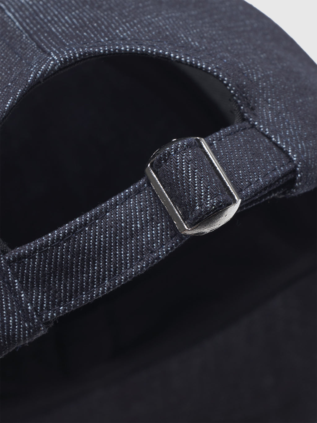 Close-up of the Gabba Sity Self Cap in dark denim, showing its silver metal buckle, adjustable fabric strap, and white-stitched Self Dry denim.