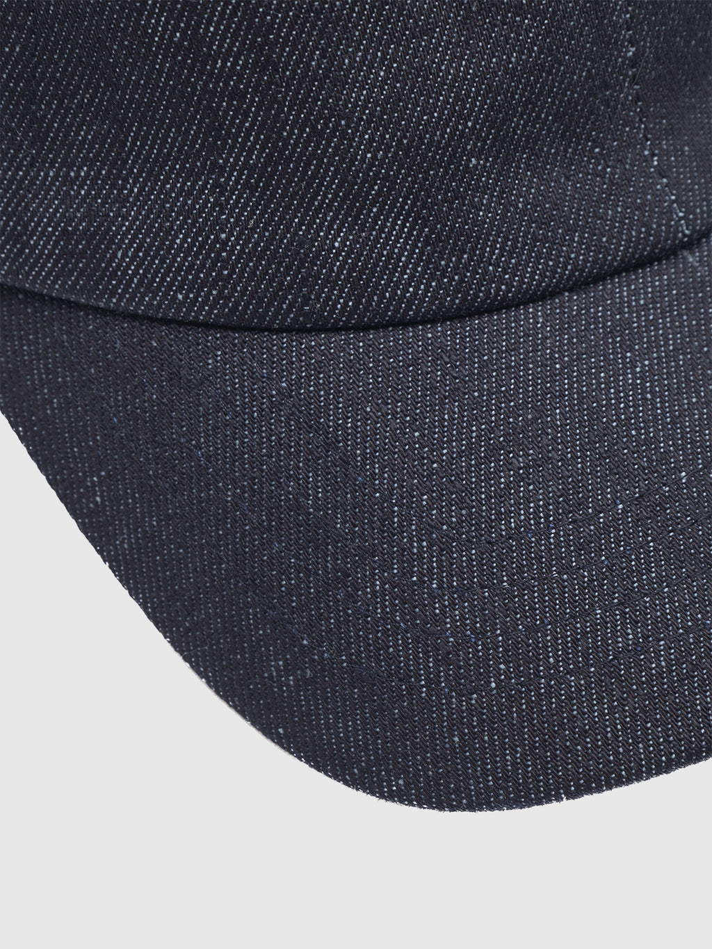 Close-up of the Gabba Sity Self Cap in dark denim on a white background, highlighting its recycled fiber fabric, rich texture, and detailed stitching.