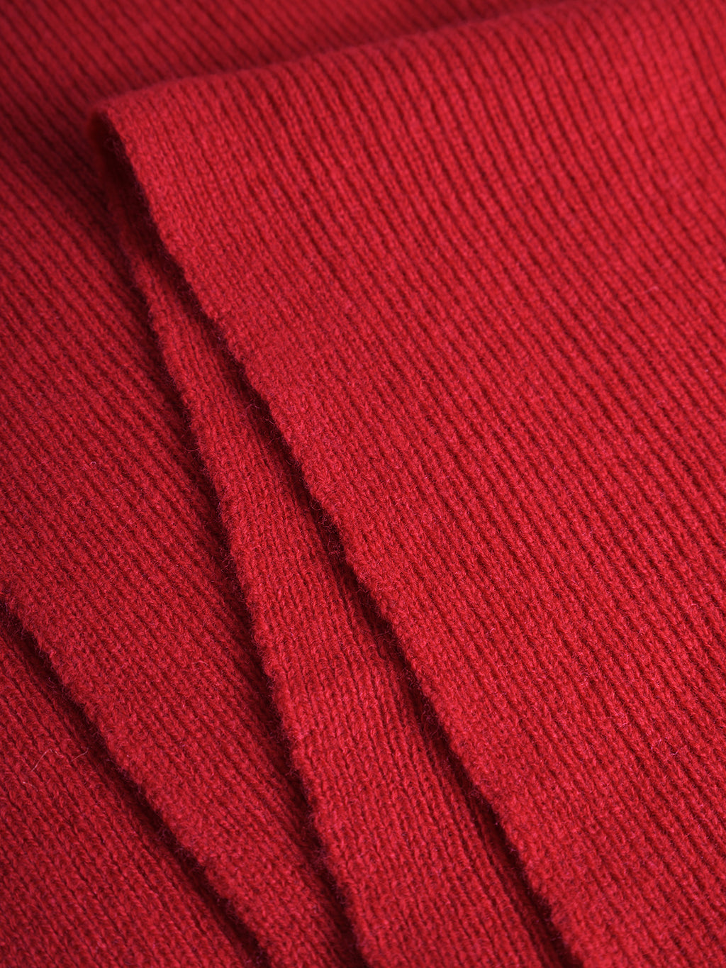 Close-up of the Gabba Biwa Aico - Red merino wool scarf, highlighting its folded ribbed texture and material quality.