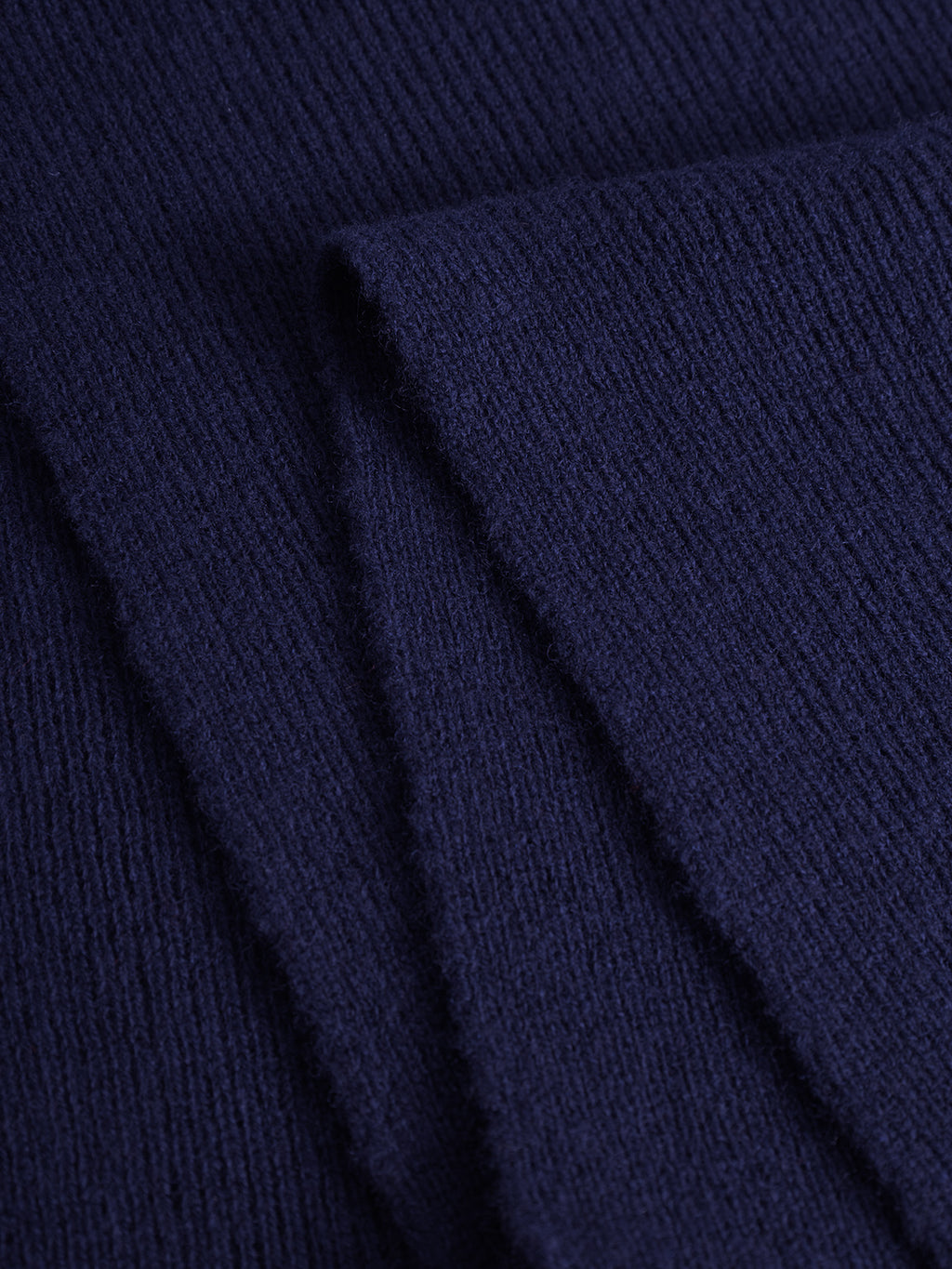 Close-up of the Biwa Aico - Navy scarf by Gabba, showing its folded ribbed knit design and textured merino wool material.