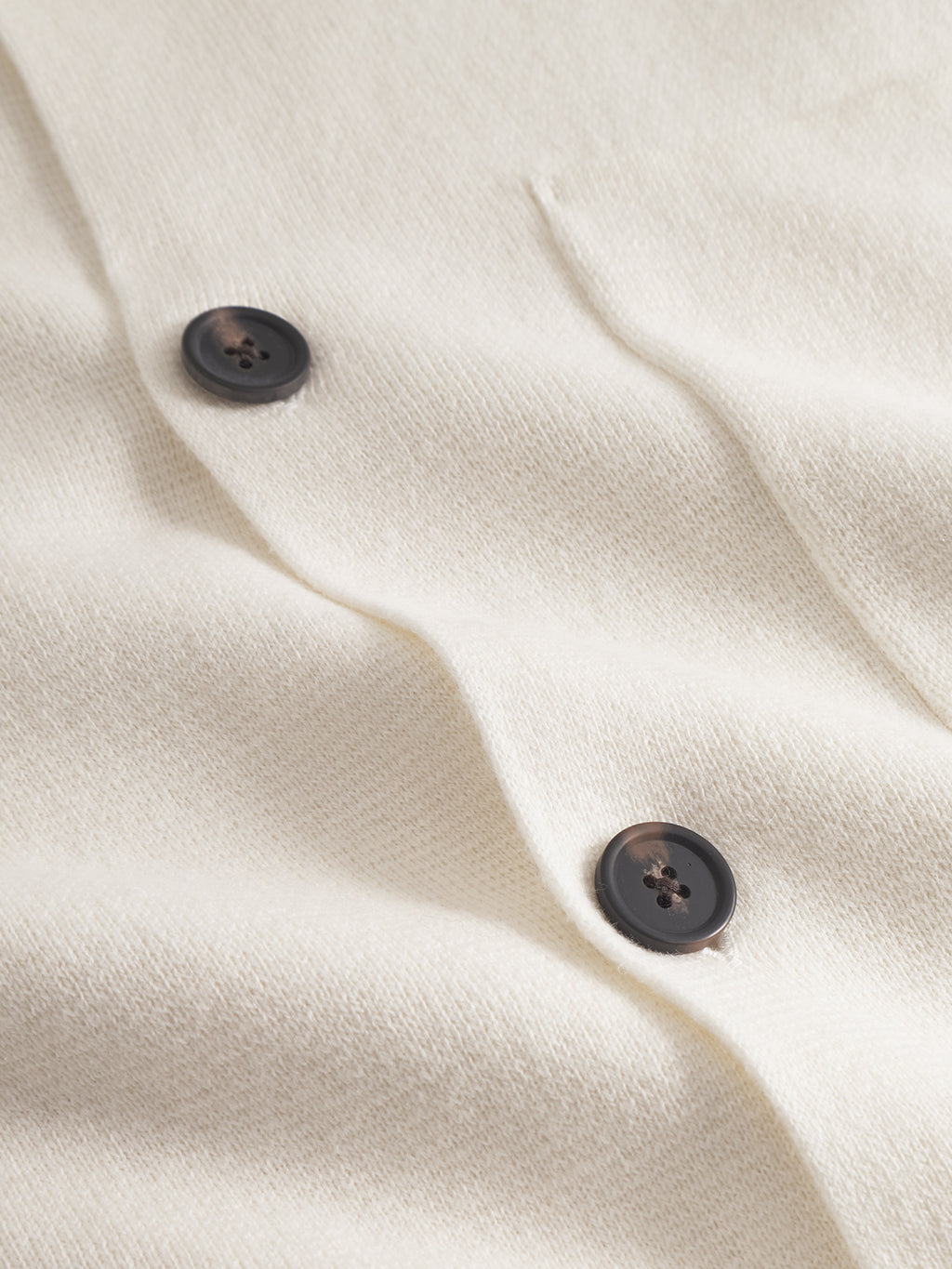 Close-up of the Gabba Blanko New Cardi LS in off white, showcasing its soft, textured fabric and dark buttons—ideal for minimalist layering.