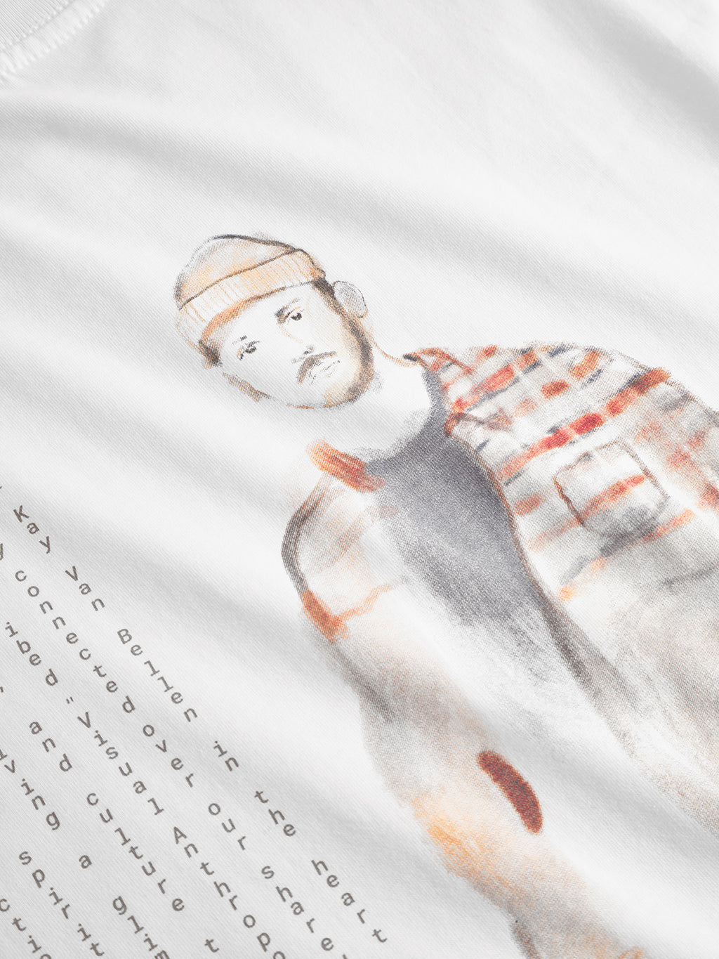 The Gabba Dune Kay Man Bauw SS GOTS - White is a minimalist tee crafted from GOTS-certified organic cotton, with a watercolor-style man in a beanie and plaid shirt plus stylized text at the lower left.