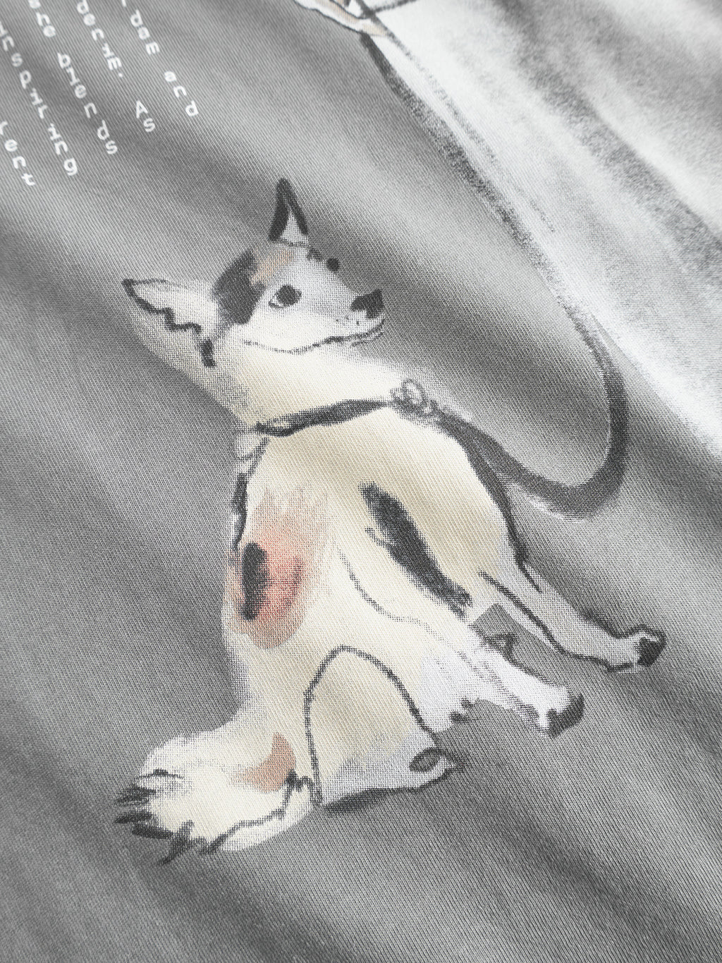 The Gabba Dune Kay Man Bauw SS GOTS T-shirt in Dust Sage Green features a minimalist, watercolor-style dog illustration on GOTS-certified organic cotton. The design shows a light-coated dog with dark ears and brown spots sitting and looking up.