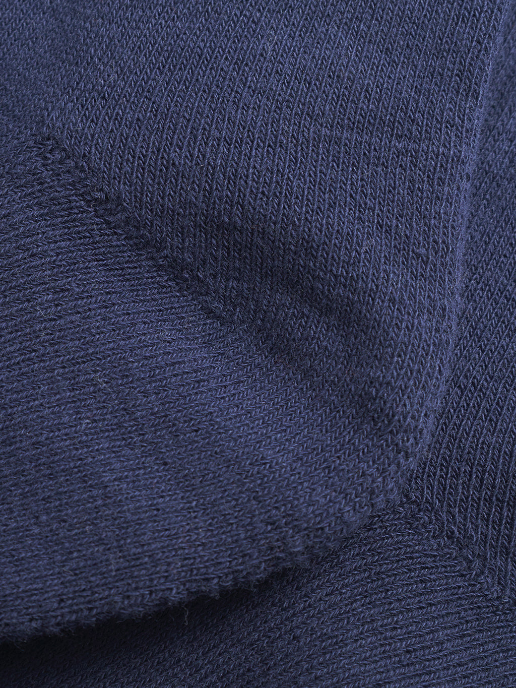 Close-up of Gabbas Zino Socks in navy, featuring dark blue knitted fabric with visible stitches, angled seams, and overlapping sections—evoking the cozy texture perfect for everyday wear.