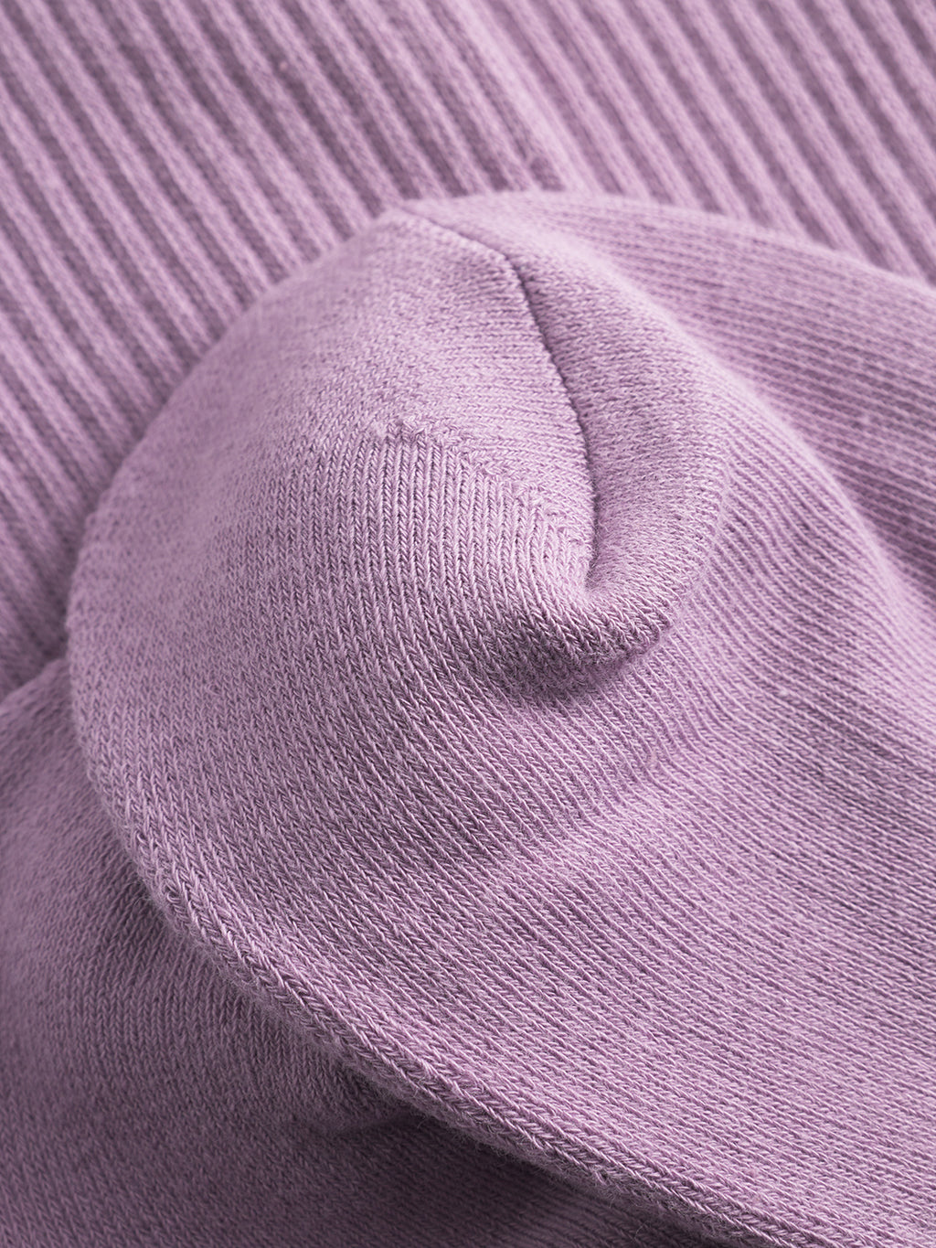 Close-up of Zino Socks - Dust Purple by Gabba, featuring lavender knit fabric with soft curves overlapping a ribbed background. The detailed texture and stitching showcase the breathable cotton and premium comfort of these socks.