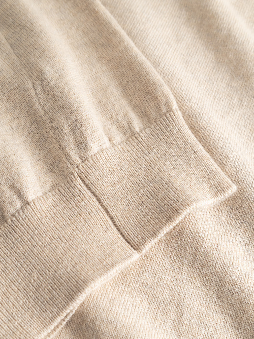 Close-up of the Gabba Aris Prex - Sand sweater, highlighting its beige cashmere ribbed cuff texture and soft, smooth fabric.