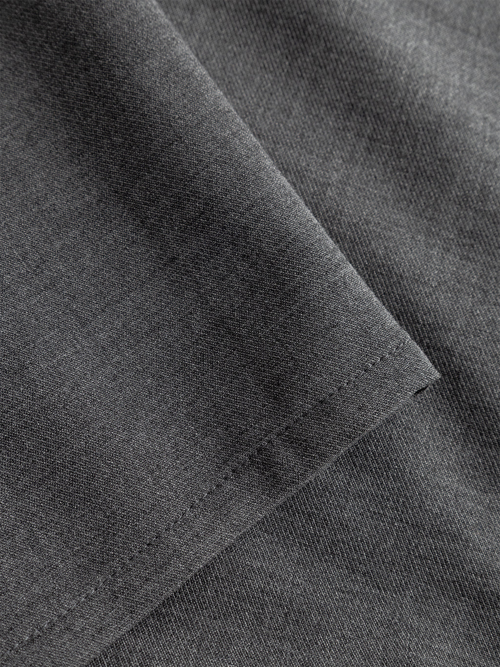 Close-up of Firenze Phin Cropped GRS - Dk. Grey by Gabba, featuring neatly folded fabric with fine texture and edge stitching—ideal for versatile, formal styling in cropped tailored trousers. The smooth, heathered finish highlights its quality cotton blend.
