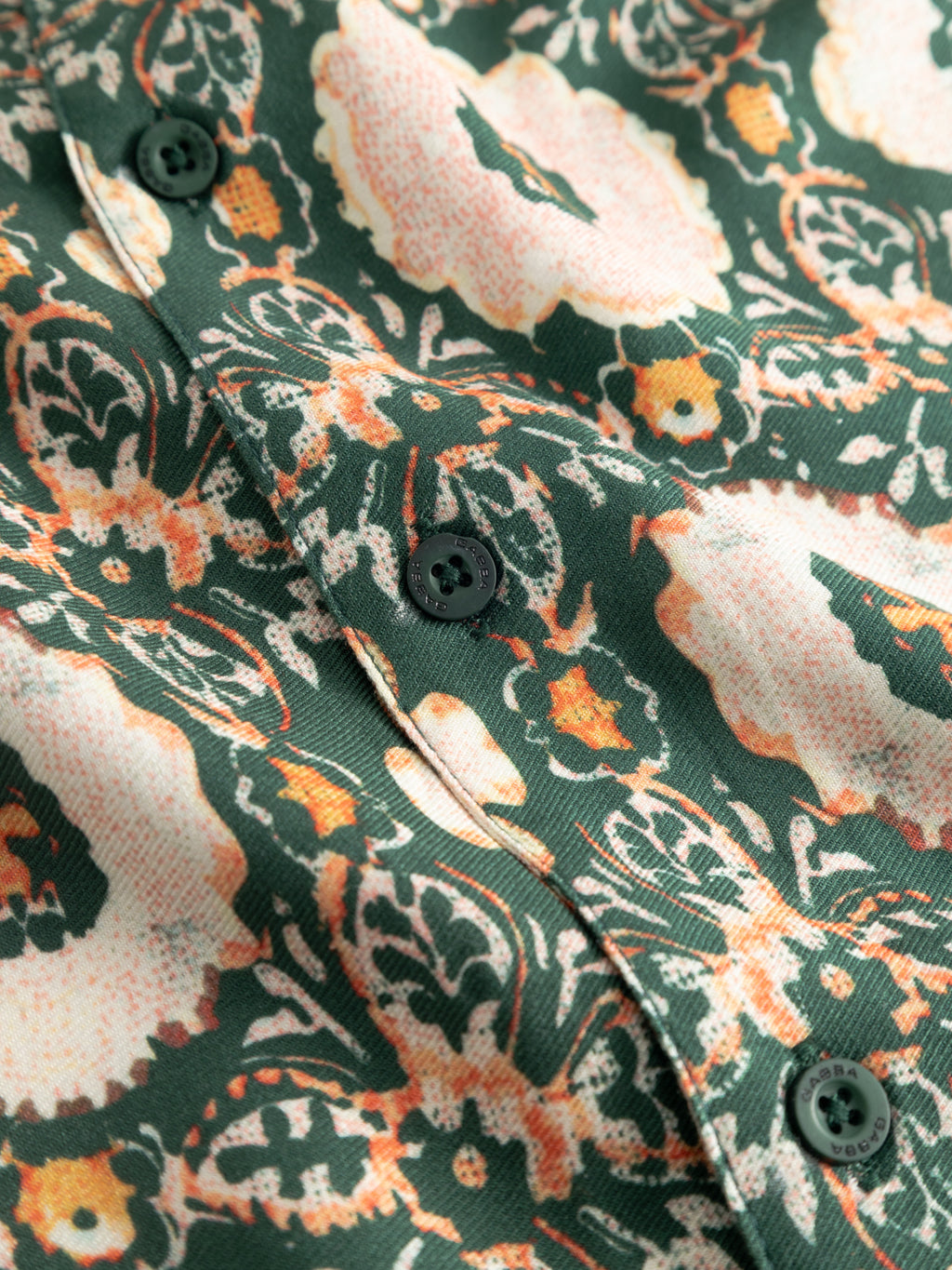 Close-up of the Gabba GABsven Reg Resort Oro SS Shirt in a green pattern, with an abstract floral viscose twill fabric and green buttons along the center.