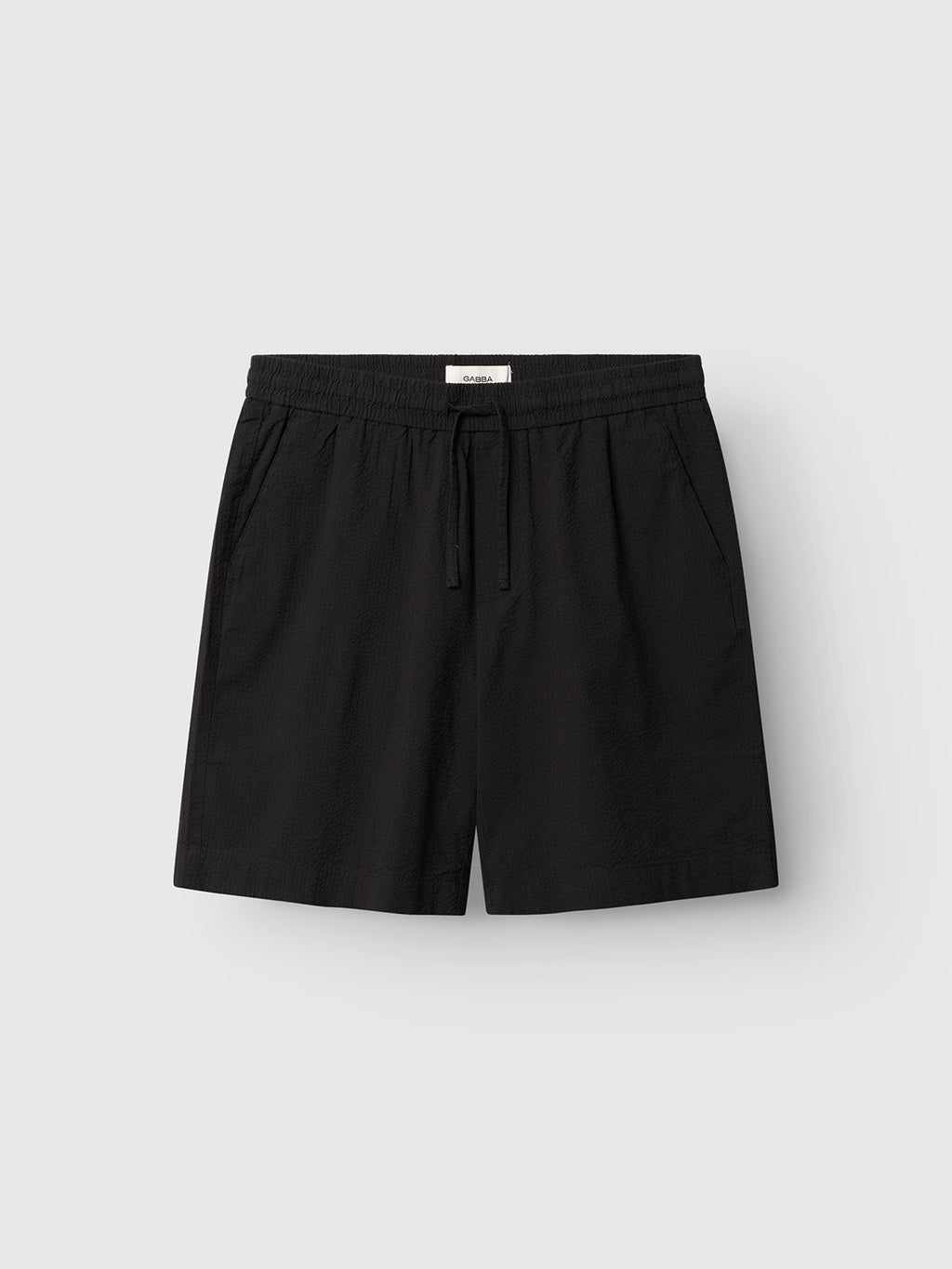 A pair of Gabba GABtommi Ker Shorts - Black, featuring an elasticated waistband, drawstring, and side pockets, displayed against a plain light gray background.