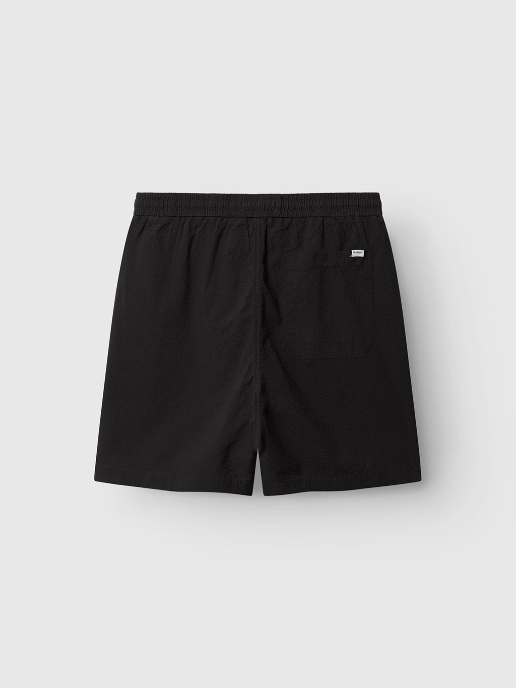 Gabba GABtommi Ker Shorts - Black, shown from the back. These regular-fit shorts have an elasticated waistband, a right-side patch pocket with a small white tag, and are displayed on a plain light gray background.