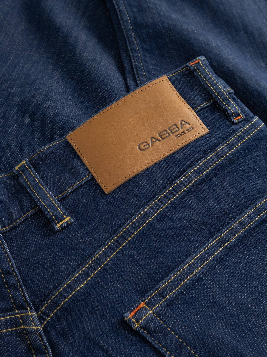 Close-up of Gabba GABalex SX Cropped Jeans in dark denim, featuring yellow stitching, belt loops, and a tan leather patch on the waistband embossed with 