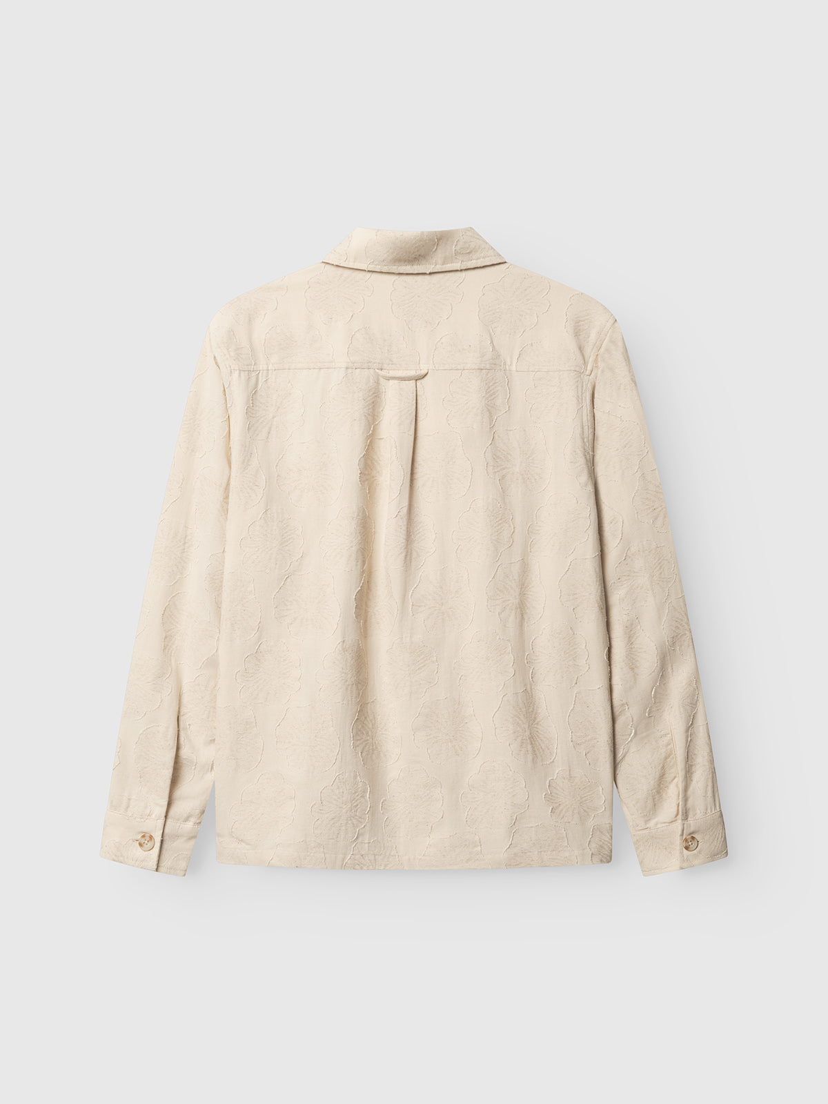Back view of the Gabba GABaustin Reso Raw LS Overshirt in Lt. Sand, a regular fit jacquard-woven cotton piece with subtle cut-out floral pattern, collar, buttoned cuffs, and back pleat detail, shown against a light gray background.
