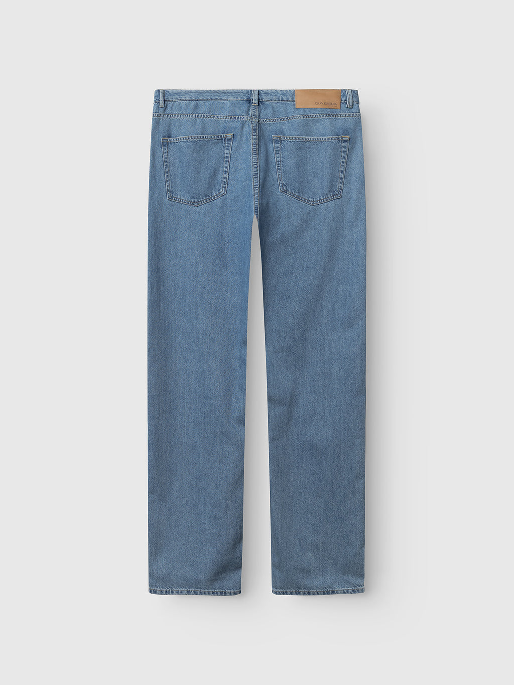 Back view of Gabba GABnoah Brook Jeans - Denim wash in light blue, loose-fit style with two back pockets and a tan leather patch on the waistband, shown against a plain white background.