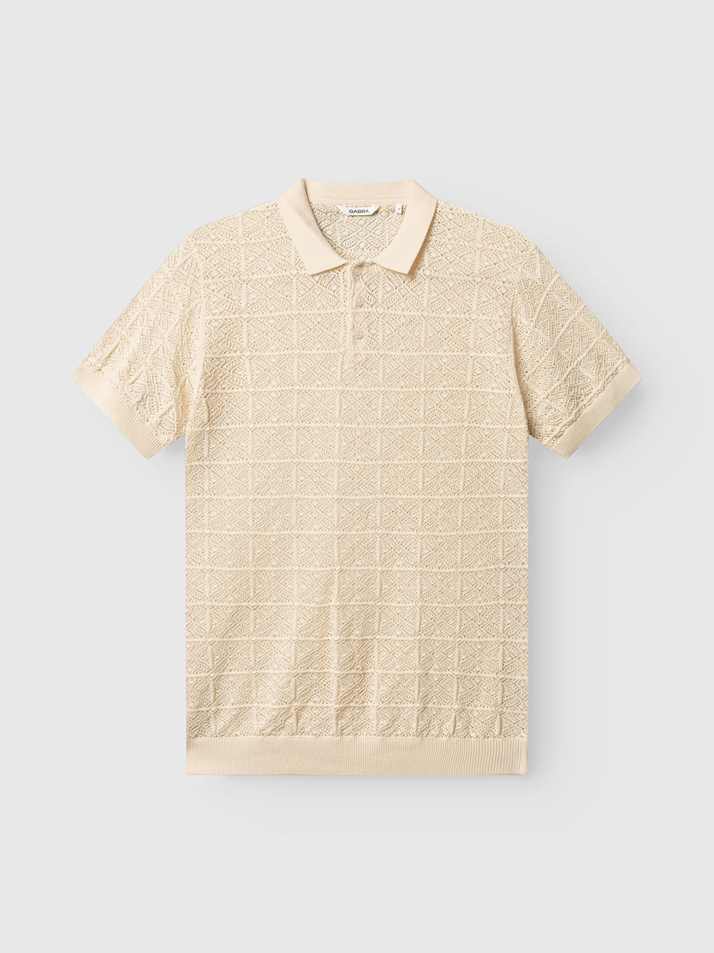 The Gabba GABbenson Fiwi SS - Birch is a beige short-sleeve polo with an open hand-knit textured grid pattern, classic collar, and ribbed cuffs and hem, shown against a plain light background.