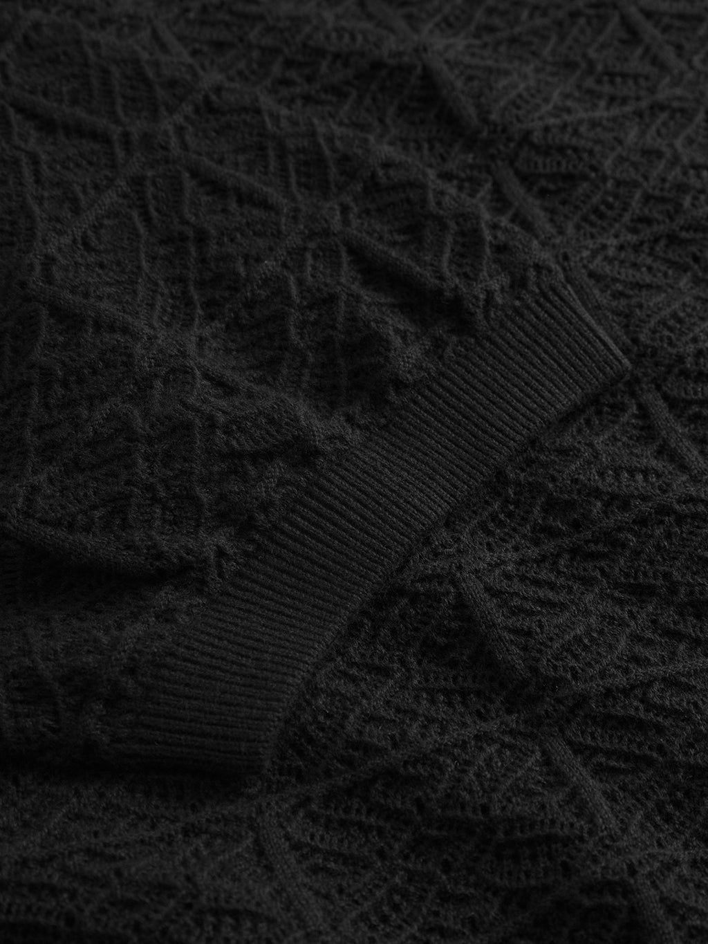 Close-up of the Gabba GABbenson Fiwi SS - Black, featuring a black knit polo fabric with a ribbed cuff and intricate geometric pattern, highlighting its detailed texture and stitching.