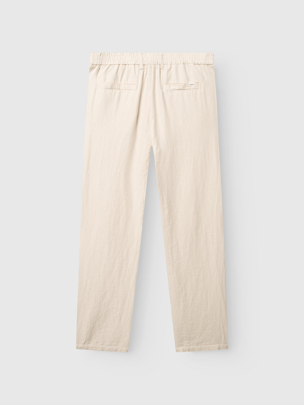 The Gabba GABnapoli 19 Lino Pant in Birch features a beige straight-leg cut, elastic waistband, and two back welt pockets, shown from the back against a light gray background.