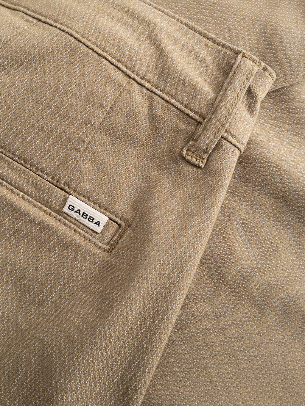 Close-up of Gabba GABjoe Nopleats Dale Pant in sand, featuring tan tapered-fit high-stretch cotton-blend, a highlighted back pocket with small white Gabba label, and visible belt loop above.