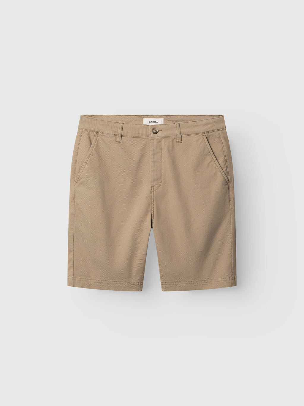 The Gabba GABjoli Nopleats Dale Shorts in Sand feature side pockets, belt loops, and a front button closure, shown laid flat on a white background.