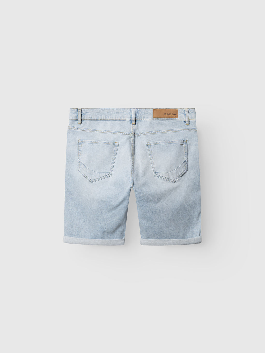 The Gabba GABmarkus Derby Shorts in light blue denim feature comfort-stretch fabric, rolled-up hems, two back pockets, and a brown leather patch—ideal for casual summer looks, shown on a plain white background.