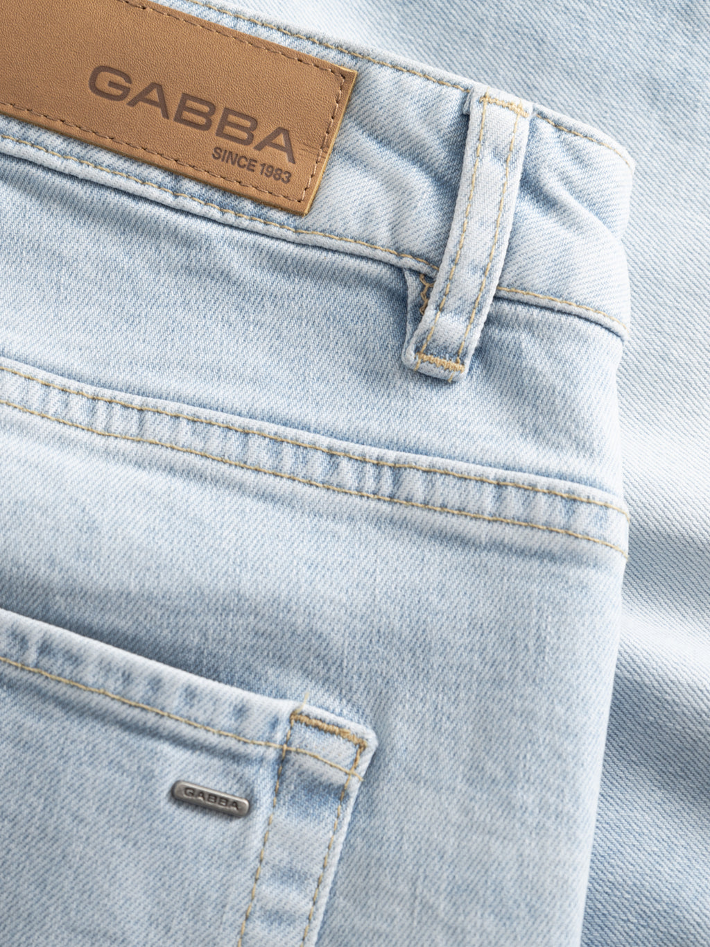 Close-up of Gabba GABmarkus Derby Shorts in light blue denim, featuring a back pocket, belt loop, and tan leather patch—ideal for casual summer looks. Stitching and fabric texture are clearly visible.