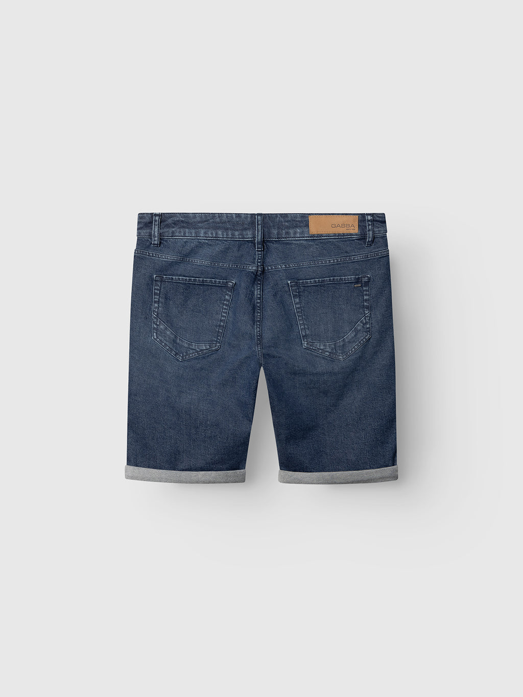 Back view of Gabba GABmarkus Derby Shorts - Denim wash, featuring blue comfort-stretch denim, rolled cuffs, classic 5-pocket design, and a brown leather patch on the waistband against a plain light background.