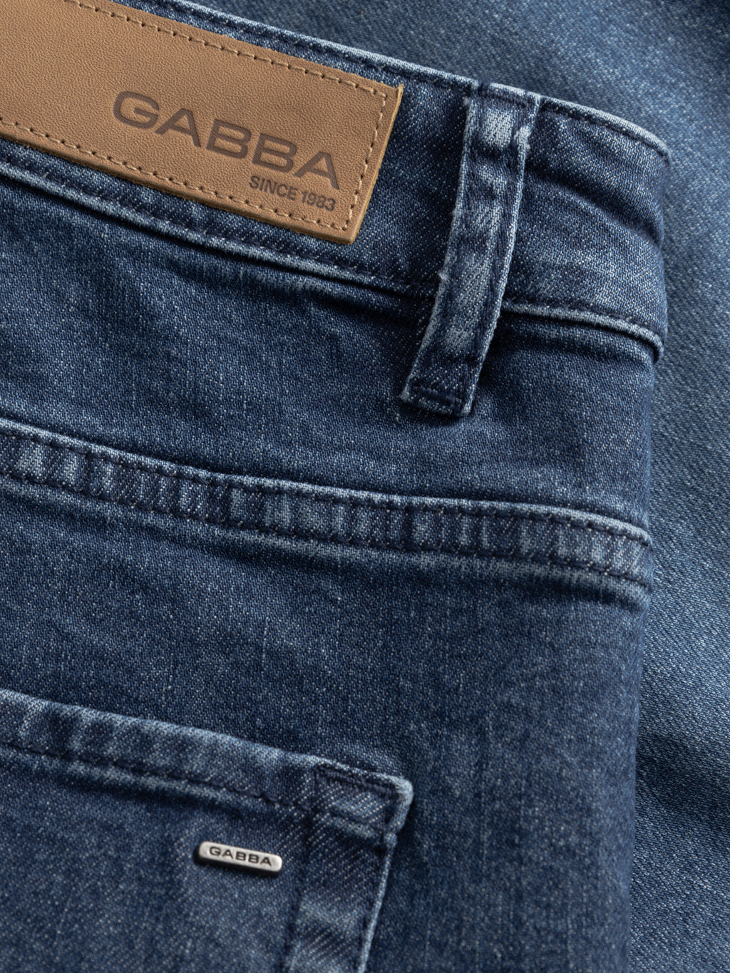 Close-up of GABmarkus Derby Shorts - Denim wash by Gabba, showing a 5-pocket design, brown leather brand patch, and a small metal tag with the Gabba name near the pocket.
