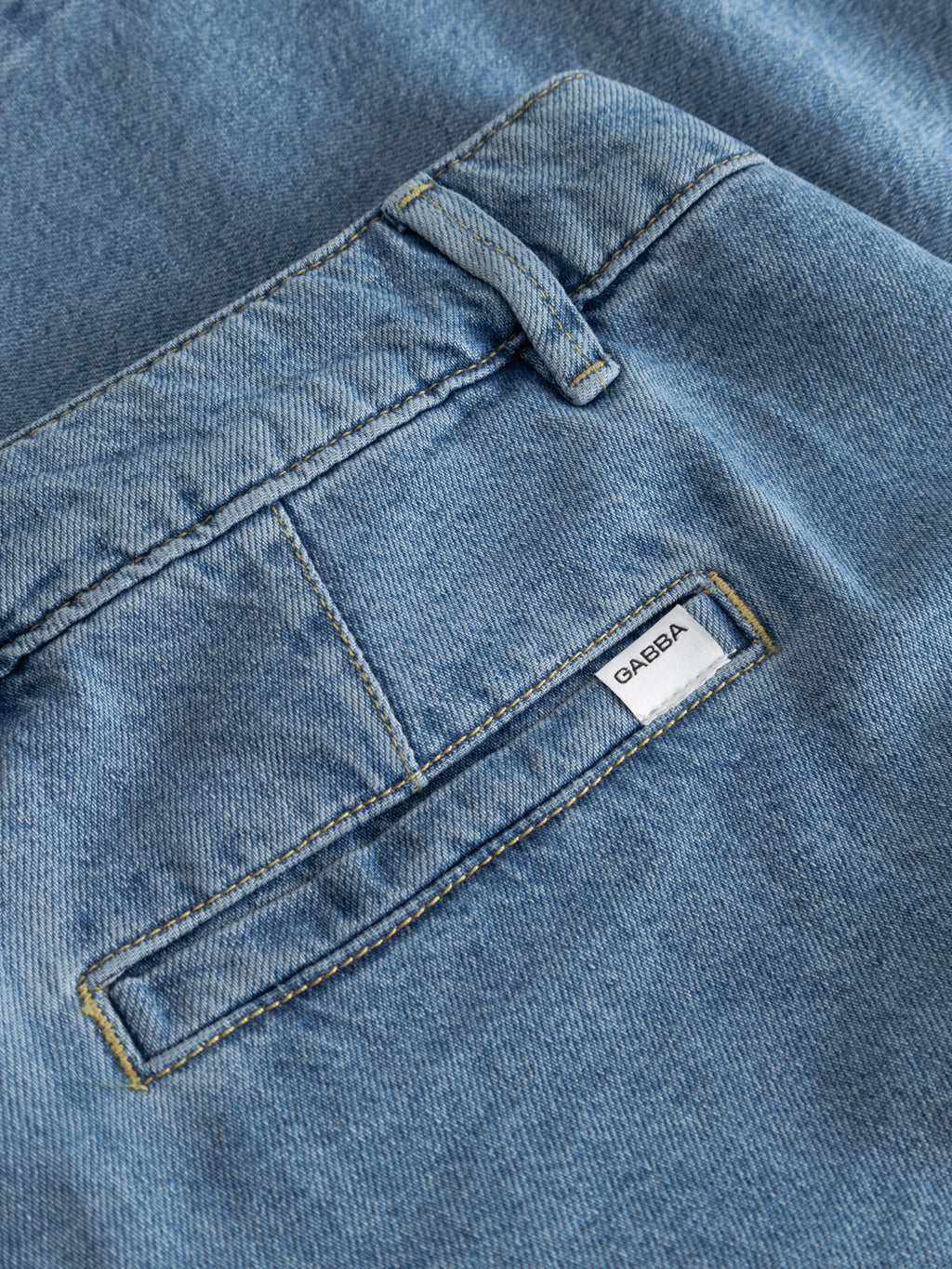 Close-up of the back pocket on Gabba's GABmoro PasBrook Shorts in denim wash, featuring a flap pocket with white Gabba label, visible stitching, and a belt loop—a relaxed fit summer essential.