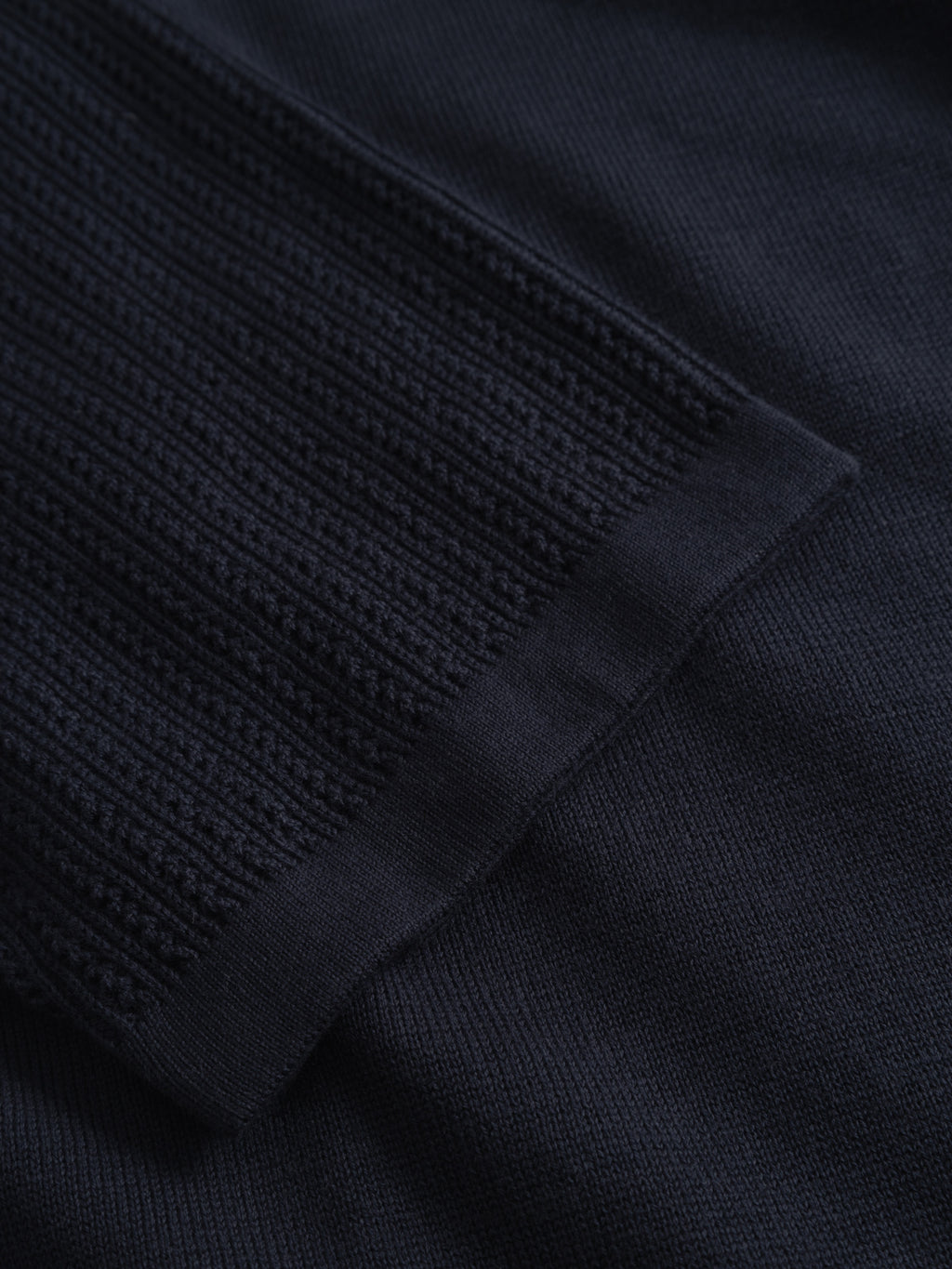 Close-up of the Gabba GABgeno Resort Bride SS Knit in Navy, highlighting the ribbed sleeve edge contrasting with a smoother, tightly woven section of the same premium material.