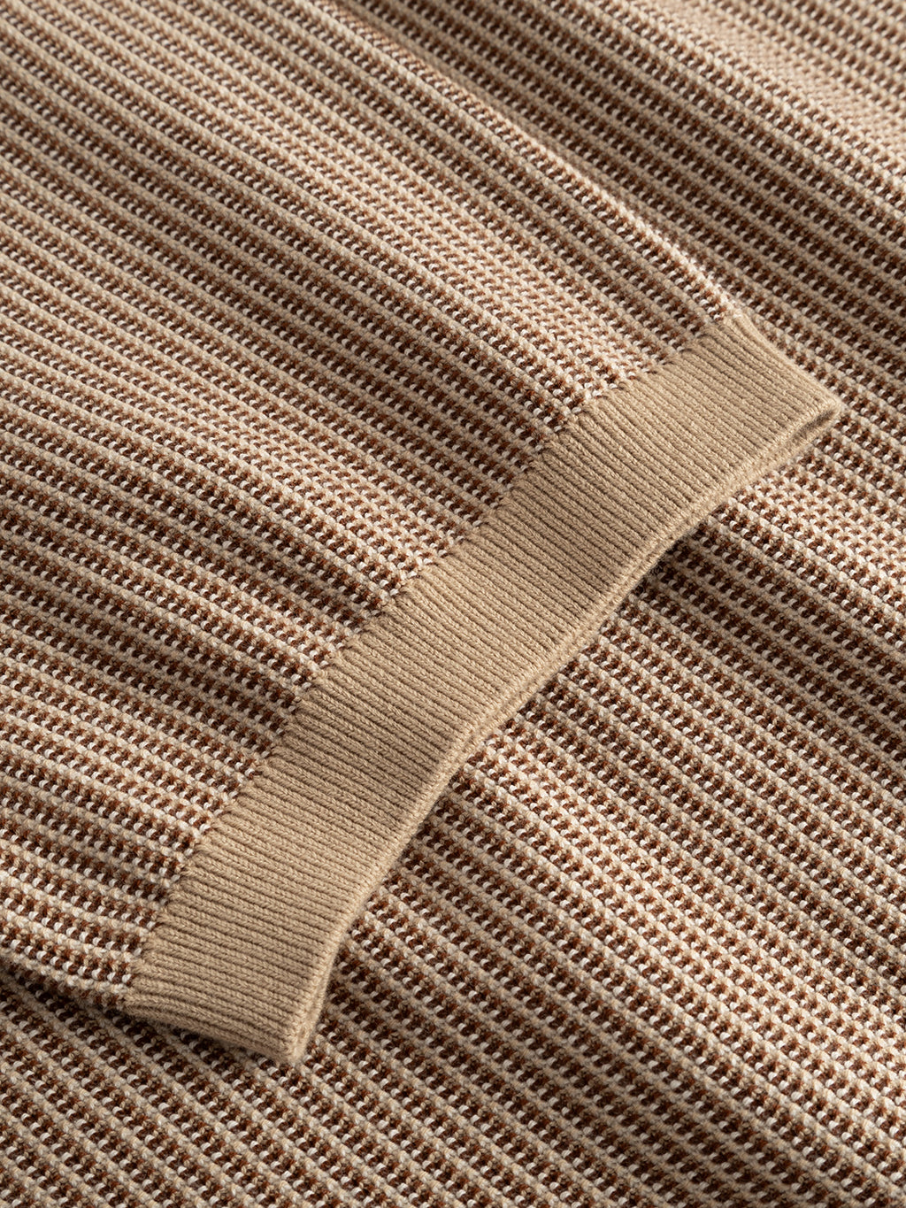 Close-up of the Gabba GABoswald Retro SS Knit in Walnut, featuring a beige waffle-knit fabric with a textured grid pattern and ribbed edge, likely from the sleeve or hem.