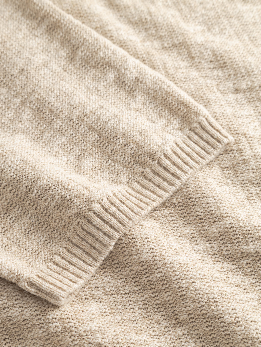 A close-up of the Gabba GABcross Alto SS Knit in Ecru highlights the soft texture, ribbed edge, and detailed knit pattern of this beige sweater.
