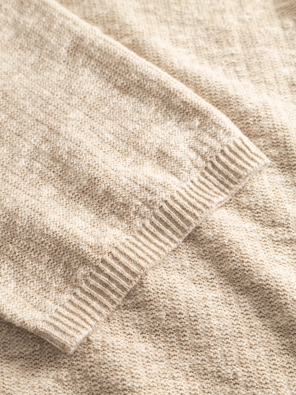 Close-up of the Gabba GABnigel Alto SS Knit in ecru, showcasing the sleeve cuff and textured knit fabric that highlights its soft and cozy feel.