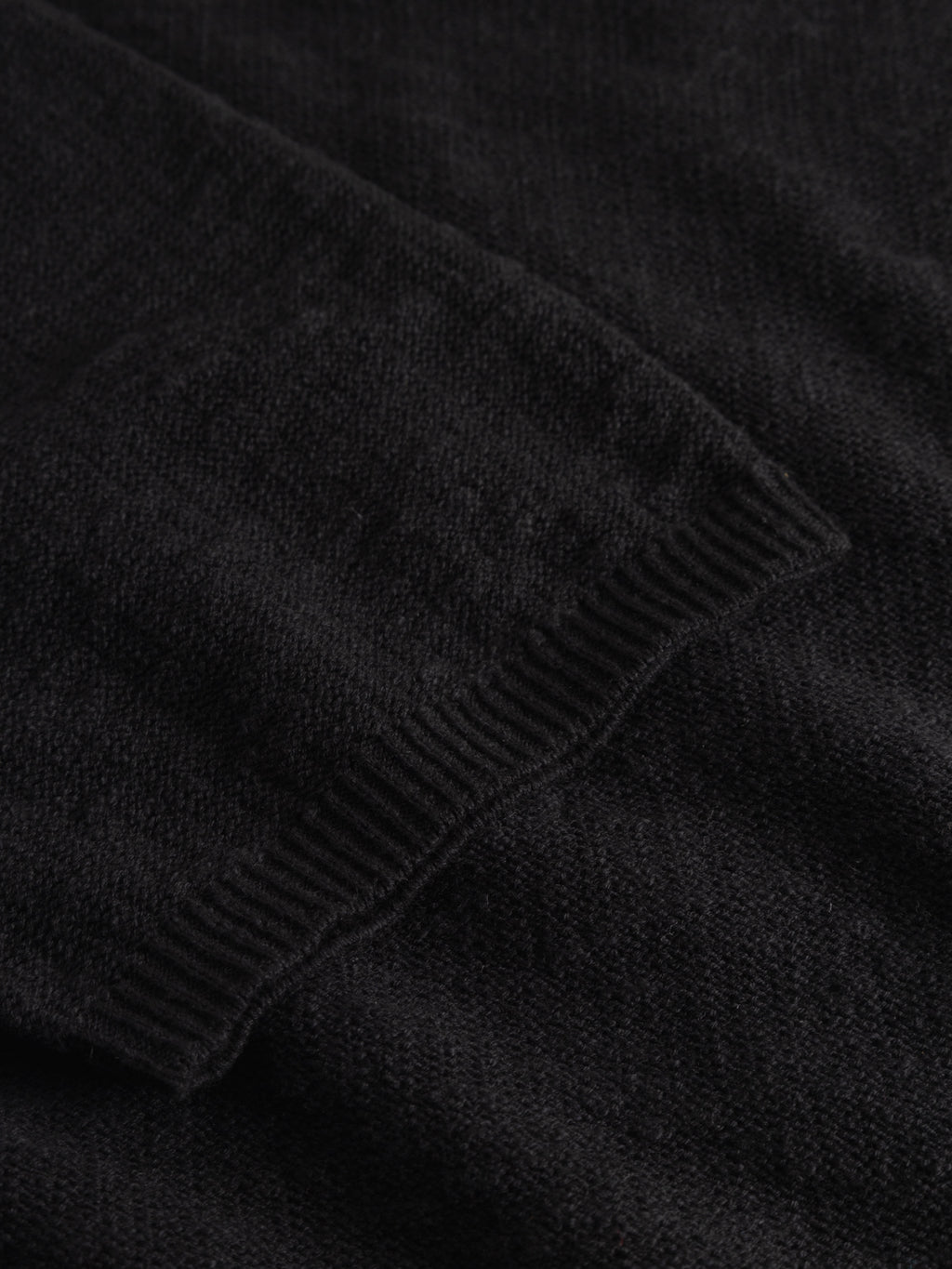 Close-up of the GABnigel Alto SS Knit - Black by Gabba, highlighting the ribbed cuff and visible knit texture, showcasing quality craftsmanship typical of this sweater.