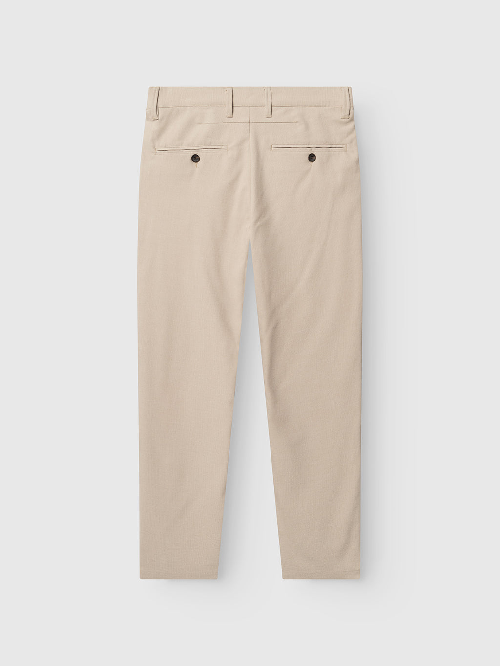 The Gabba GABpaul Deme Pant in Birch is shown laid flat on a white background, displaying its beige slim fit, two back pockets with dark buttons, and belt loops along the waistband.
