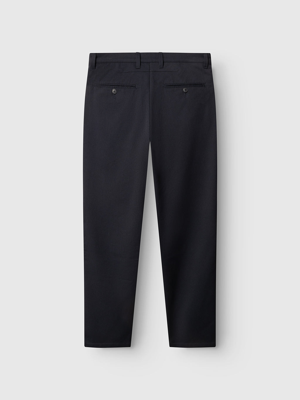 The Gabba GABpaul Deme Pant in Dark Navy is shown from the back, with two buttoned welt pockets, belt loops, a straight-leg fit, and a subtle micro-pattern, displayed against a plain light grey background.