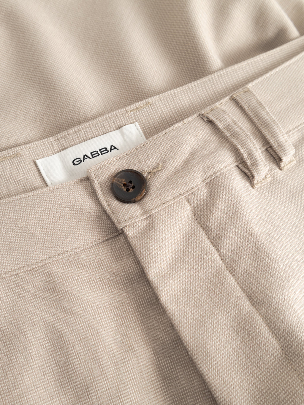 Close-up of GABjet Deme Shorts in Birch by Gabba, showcasing a classic silhouette, button closure, belt loops, and a visible white Gabba label on the waistband.